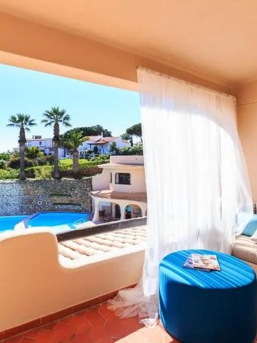 Gemütliche Terrasse mit Blick auf den Pool und Palmen im Hintergrund