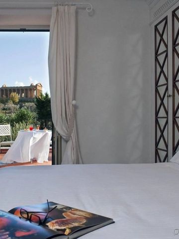 Zimmer mit offenem Fenster zur Terrasse und Aussicht auf antike Ruinen