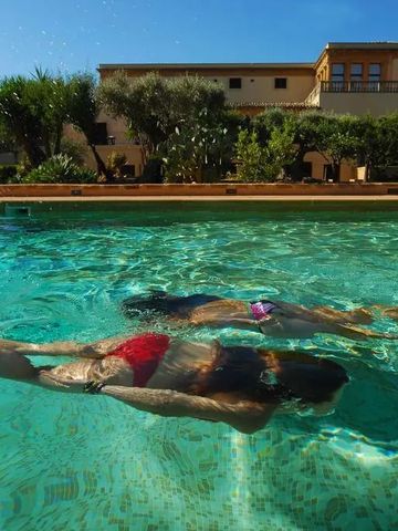 Zwei Personen schwimmen im klaren Pool des Villa Athena Resort