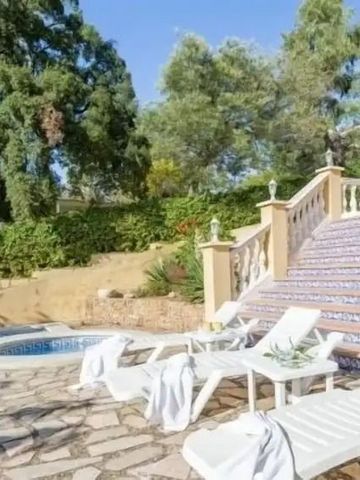 Außenbereich mit Pool und Liegestühlen umgeben von grüner Landschaft