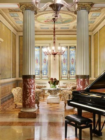 Elegante Lobby mit Flügel, Marmorsäulen und bunten Glasfenstern