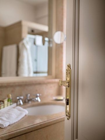 Nahaufnahme eines Badezimmerdetails mit goldener Türgriff-Verzierung im Hotel