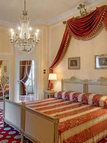 Opulentes Schlafzimmer mit Kristallleuchter und rotem Dekor
