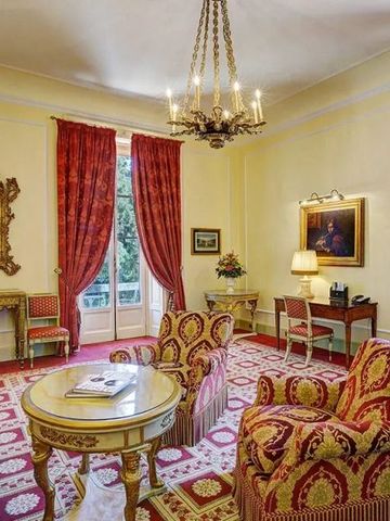 Geräumiges Wohnzimmer mit luxuriösen roten Sesseln und eleganter Dekoration