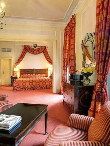 Großzügiges Schlafzimmer mit opulenter Ausstattung und stilvollen Vorhängen