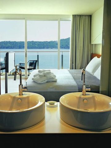 Luxuriöses Zimmer mit Blick vom Badezimmer aufs Meer durch große Fenster