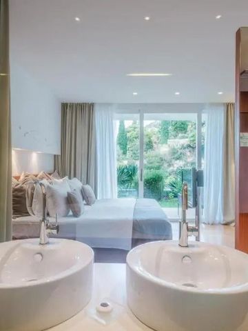 Modernes Schlafzimmer mit Blick auf grüne Umgebung durch große Fenster