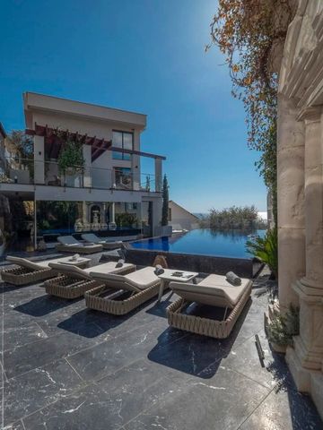 Luxuriöser Außenbereich mit Pool und stilvollen Sonnenliegen unter klarem Himmel.