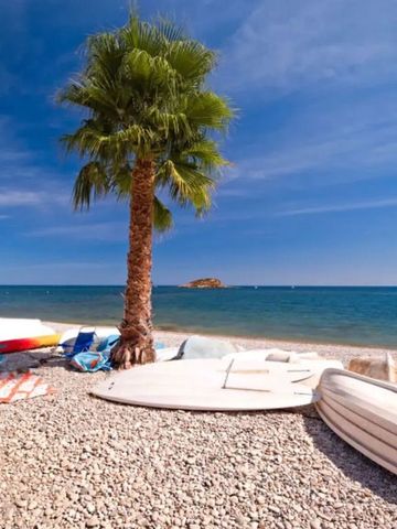 Strand mit Palmen und Booten unter klarem Himmel