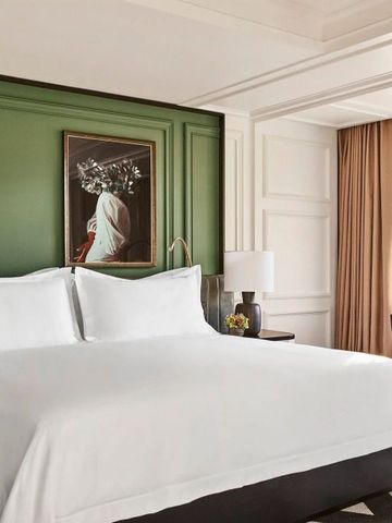 Luxuriöses Zimmer in dezenter Farbpalette mit grünem Akzent und moderner Kunst