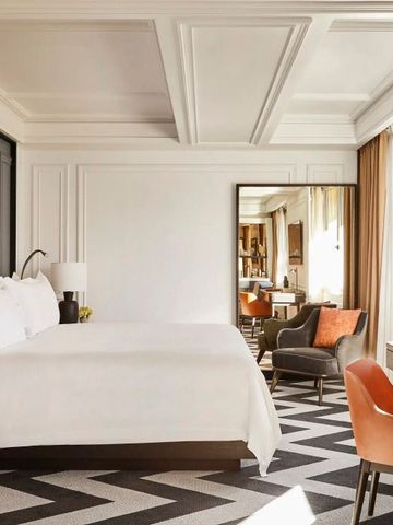 Schickes Zimmer mit großen Fenstern und eleganter Möblierung in neutralen Tönen