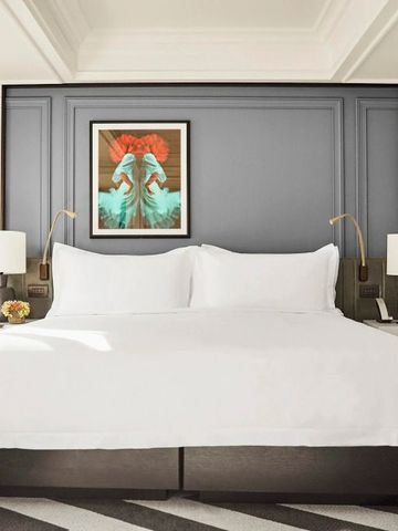 Luxuszimmer mit grauer Akzentwand und eleganten, warmen Designelementen