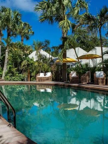 Tropischer Pool von Palmen umgeben unter blauem Himmel