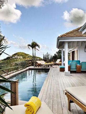 Pool mit Liegen und tropischer Vegetation auf Holzterrasse