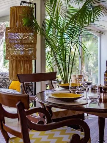 Eleganter Essbereich mit Holzmöbeln und tropischen Pflanzen