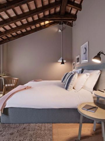 Gemütliches Schlafzimmer mit Holzbalkendecke und Doppelbett im Hotel Meneghetti