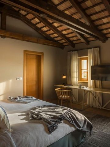 Elegantes Schlafzimmer mit Holzbalken und Anwesenheit von natürlichem Licht