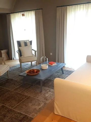 Gemütlicher Wohnraum mit weißen Sesseln und großen Fenstern im Hotel Meneghetti