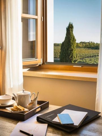 Elegantes Hotelzimmer mit Blick auf Weinberge durch ein geöffnetes Fenster