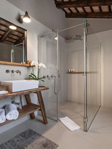 Modernes Bad mit Glasdusche und Holzelementen in einem Hotel