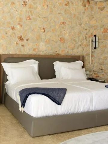 Modernes Hotelzimmer mit bequemen Doppelbett und Natursteinwand