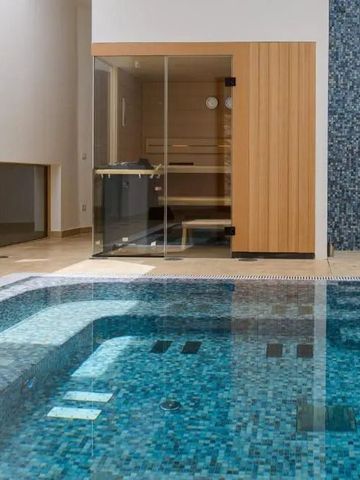 Innenpool mit angrenzender Sauna und blauen Mosaikfliesen