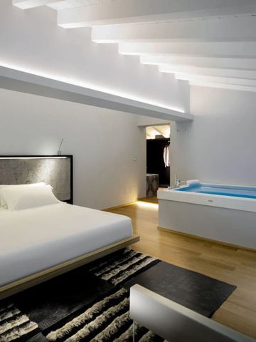 Luxus Schlafzimmer mit modernem Whirlpool im Villa Neri Resort