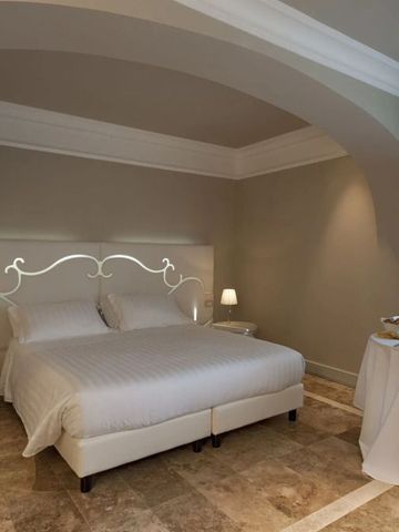 Klassisches Schlafzimmer mit elegantem Dekor im Villa Neri Resort