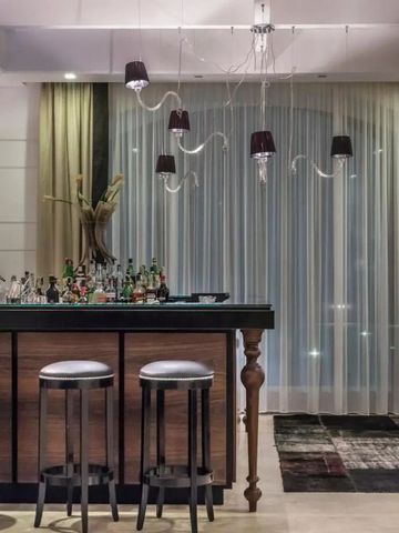 Stilvolle Hotelbar mit modernen Hockern und dekorativen Leuchten.