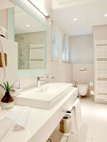 Helles und modernes Badezimmer mit großer Dusche und eleganten Armaturen