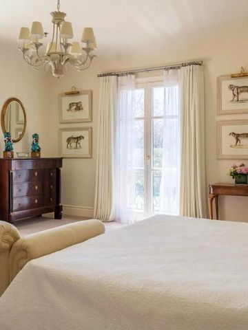 Helles Schlafzimmer mit klassischer Einrichtung und großen Fenstern