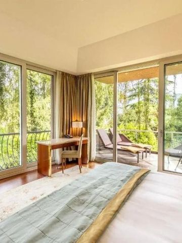 Helles Hotelzimmer mit großen Fenstern und Blick auf den Garten