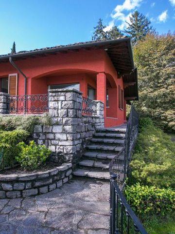 Steintreppe führt zu einer roten Villa mit üppiger Umgebung und Pflanzen