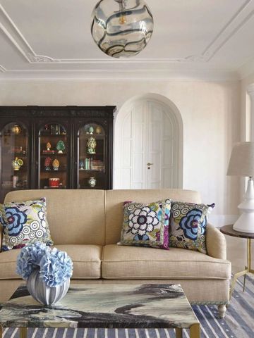 Luxuriös eingerichtetes Wohnzimmer mit stilvollen Möbeln und dekorativen Kissen.