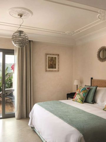 Lichtdurchflutetes Schlafzimmer mit Zugang zu einer Terrasse und Bergblick.