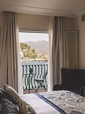 Elegantes Zimmer mit einem Balkon, der einen Ausblick auf das Meer bietet.