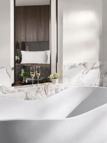 Elegantes Badezimmer mit freistehender Badewanne und Marmorverkleidung