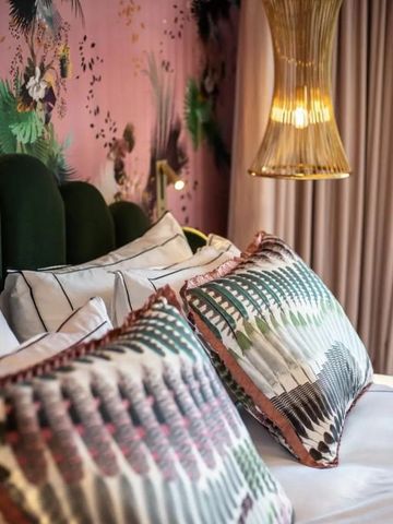 Detail eines stilvoll dekorierten Hotelzimmers mit Kissen und hängender Lampe