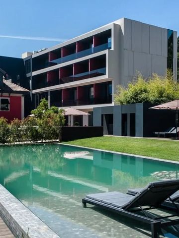 Außenansicht eines luxuriösen Hotels mit Infinity-Pool und Sonnenliegen