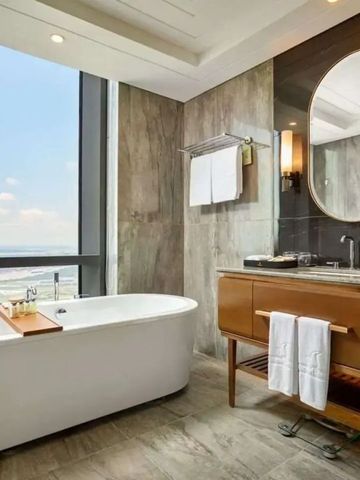 Modernes Badezimmer mit freistehender Badewanne und großem Fenster