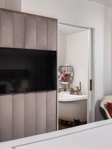 Elegantes Hotelzimmer mit großem Flachbildfernseher und modernem Bad.