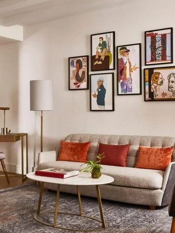 Wohnbereich mit eleganter Sofagarnitur und Kunstwerken an der Wand.