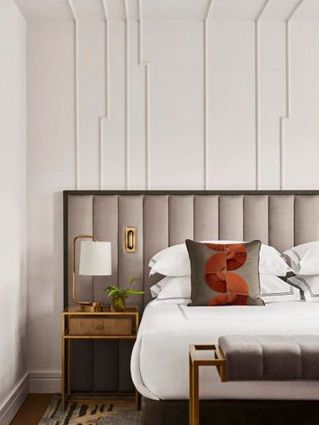 Hochwertiges Hotelbett mit dekorativen Kissen und stilvoller Wandgestaltung.