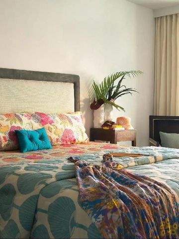 Elegantes Hotelzimmer mit floralem Dekor und Aussicht auf das Meer