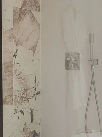 Dusche mit Glaswand und Marmorverkleidung im eleganten Design