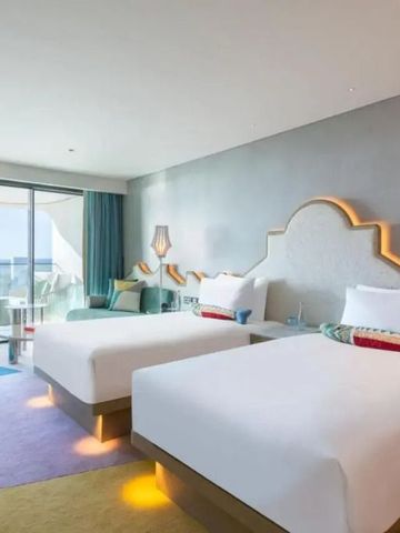 Doppelzimmer mit zwei Betten im W Algarve mit moderner Einrichtung und Balkon.