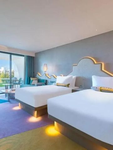 Zimmer mit zwei Doppelbetten und Balkon mit Glasfenstern im W Algarve