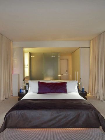 Geräumiges Hotelzimmer mit Kingsize-Bett und stilvoller Beleuchtung