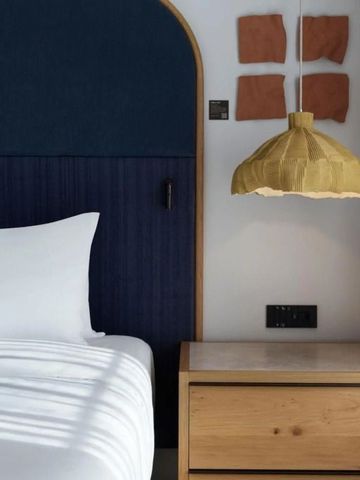 Modern eingerichtetes Hotelzimmer mit elegantem Holz-Nachttisch und Designerlampe