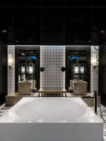 Luxuriöses Badezimmer mit freistehender Badewanne und zwei Waschbereichen